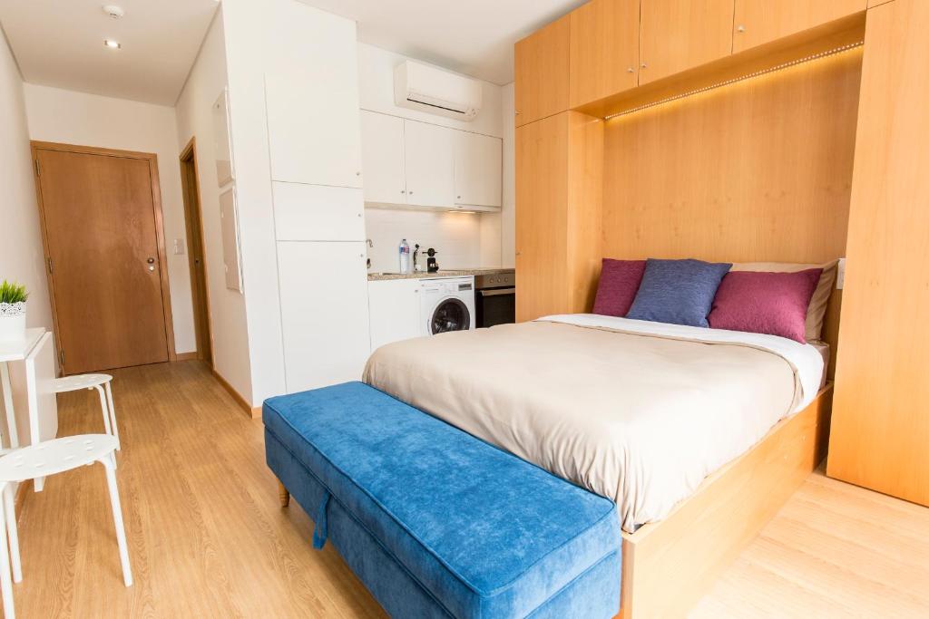 1 dormitorio con 1 cama grande y banco azul en Porto 271 Mouzinho Apartamentos en Oporto