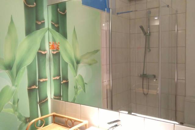 a bathroom with a shower and a sink and a mirror at Apartament Monika in Sopot