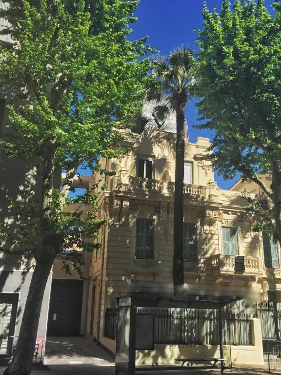 un vieux bâtiment avec un palmier devant lui dans l'établissement Le Cedre Bleu, à Nice