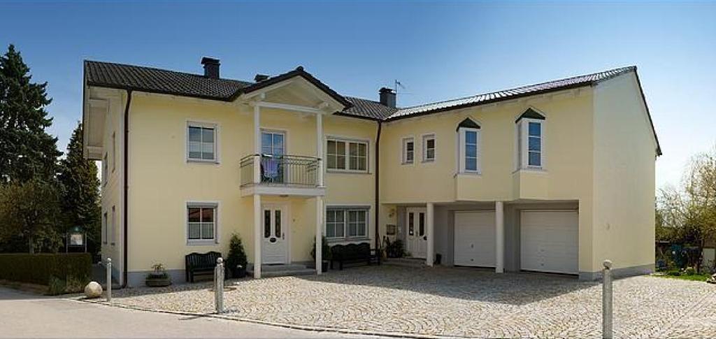 a large white house with two garage at Appartementhaus Stangl in Bad Füssing