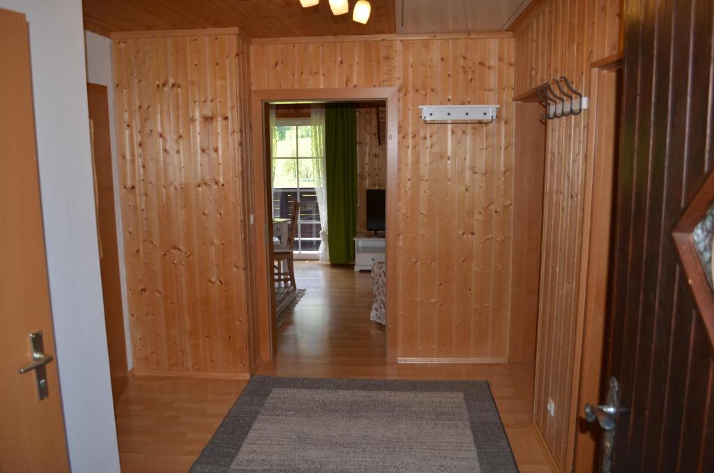 um corredor com paredes com painéis de madeira e um quarto com uma porta em Bauernhof König em Anger