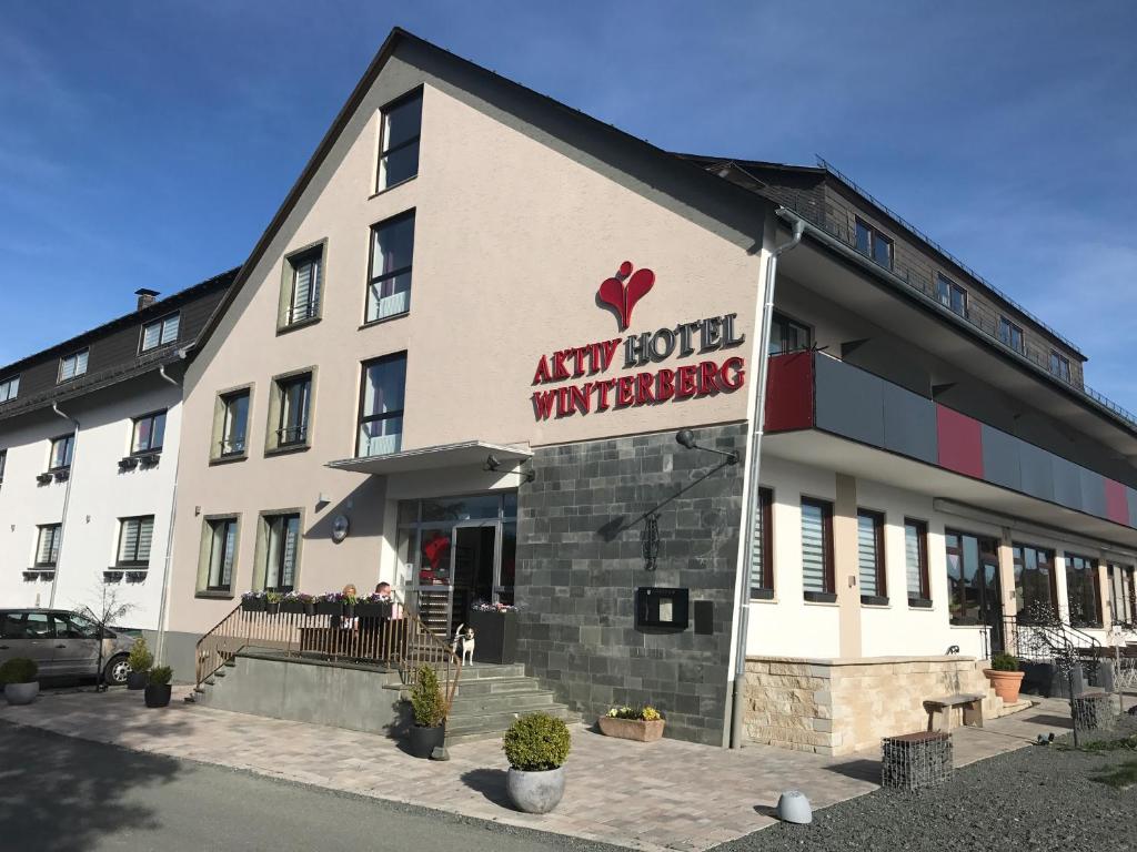 un grand bâtiment blanc avec un panneau indiquant tout hôtel vancouver dans l'établissement Aktiv Hotel Winterberg, à Winterberg