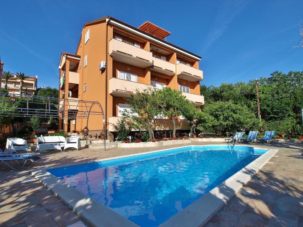 una piscina frente a un edificio en Apartments Bene, en Rab