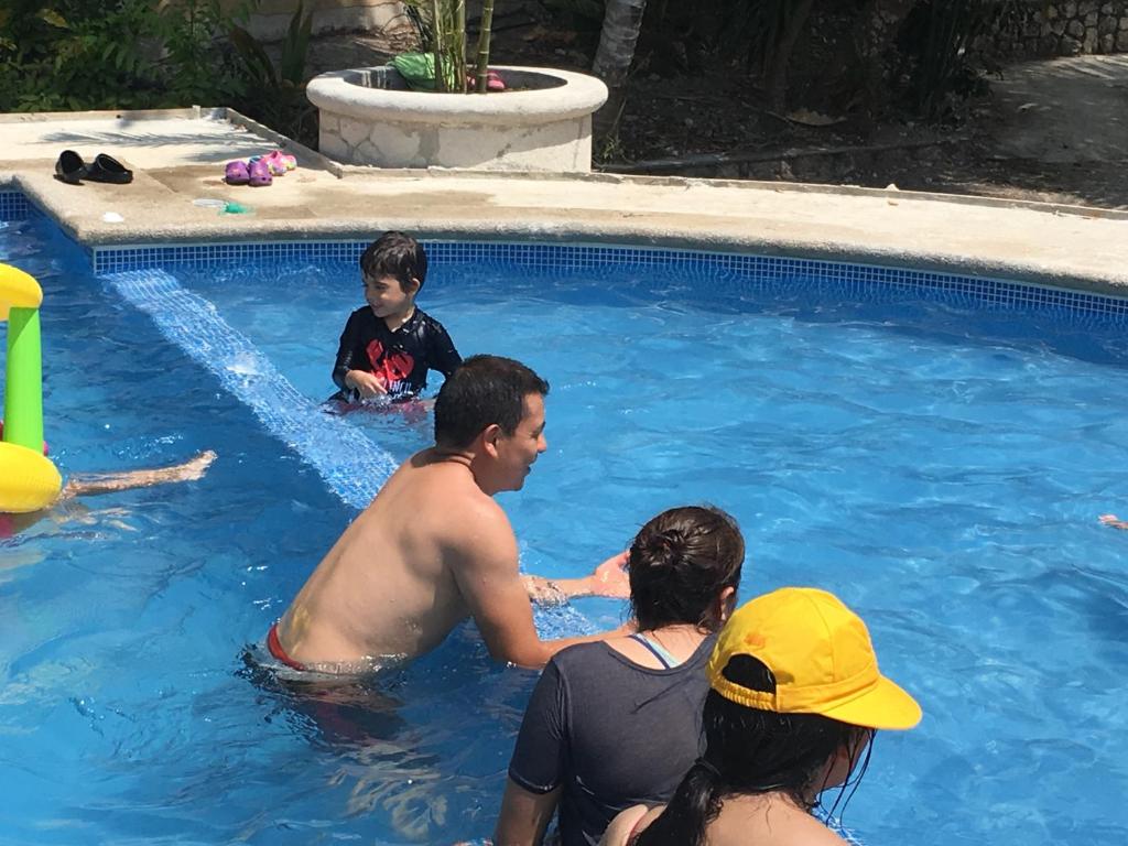 un grupo de personas en una piscina en Hotel Bahia Taitza, en San José