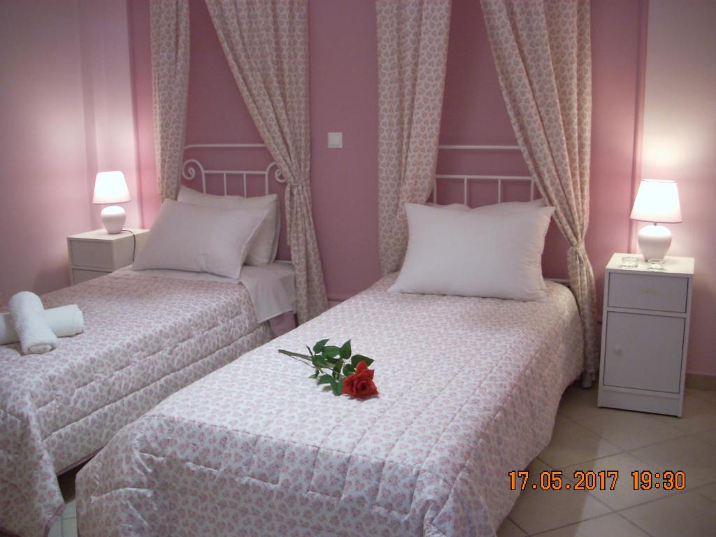 a bedroom with two beds with flowers on them at Iris Apartments in Apolpaina