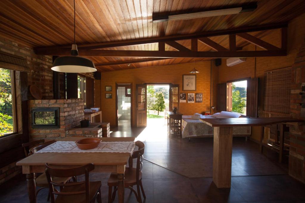 ein Zimmer mit Tischen und Stühlen und einem Kamin in der Unterkunft Loft no campo próximo ao Vale dos Vinhedos in Garibaldi
