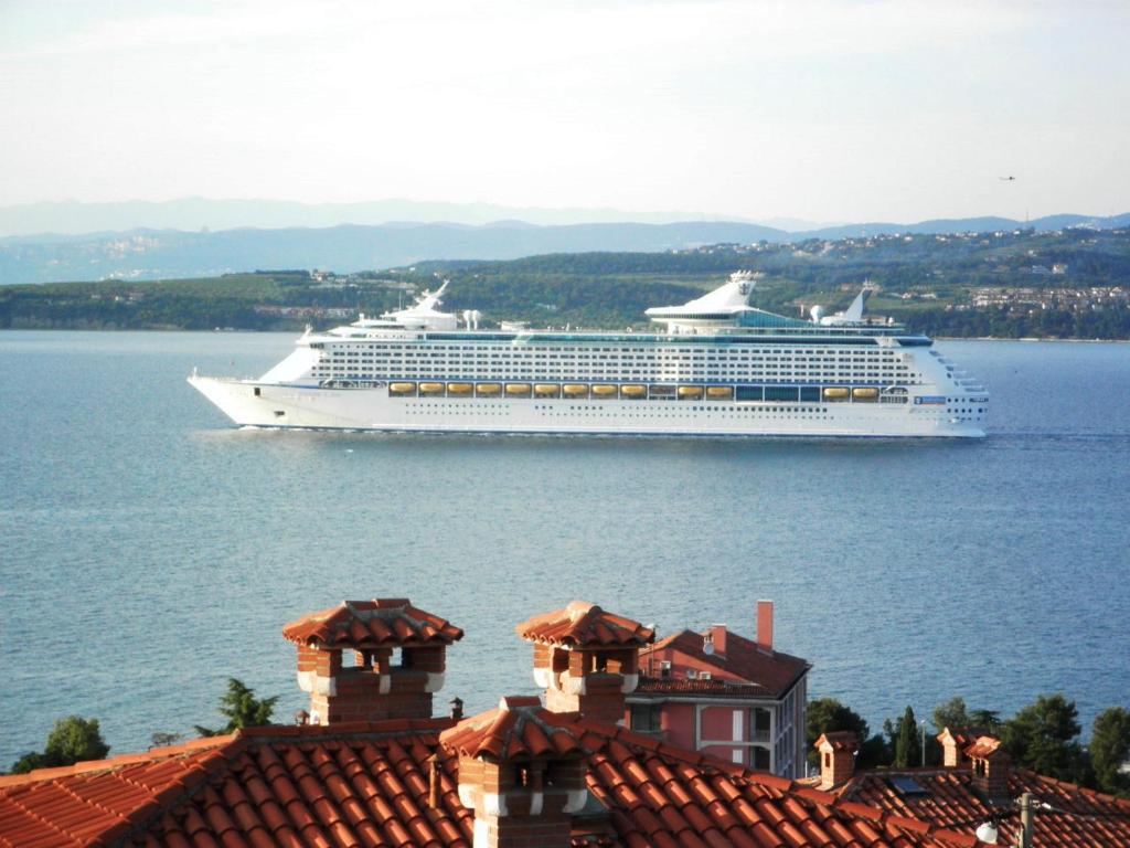 a large cruise ship on the water with buildings at Apartmaji Zonta in Koper