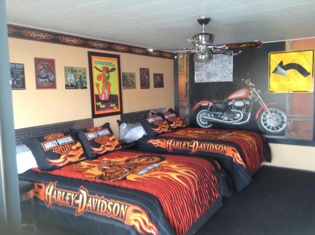 two beds in a bedroom with a motorcycle on the wall at Galaxy of Harley Bikers Between Bryce and Zion in Hatch