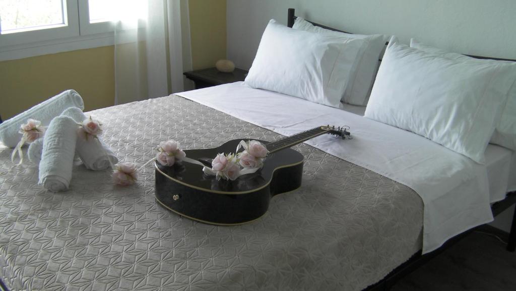 スカラ・カリラキスにあるMeji Houseのギターとぬいぐるみのベッド