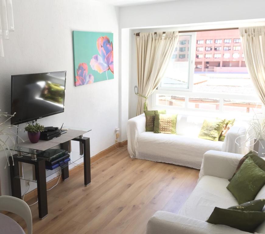 a living room with a white couch and a tv at Ramon - Y - Cajal in Fuengirola