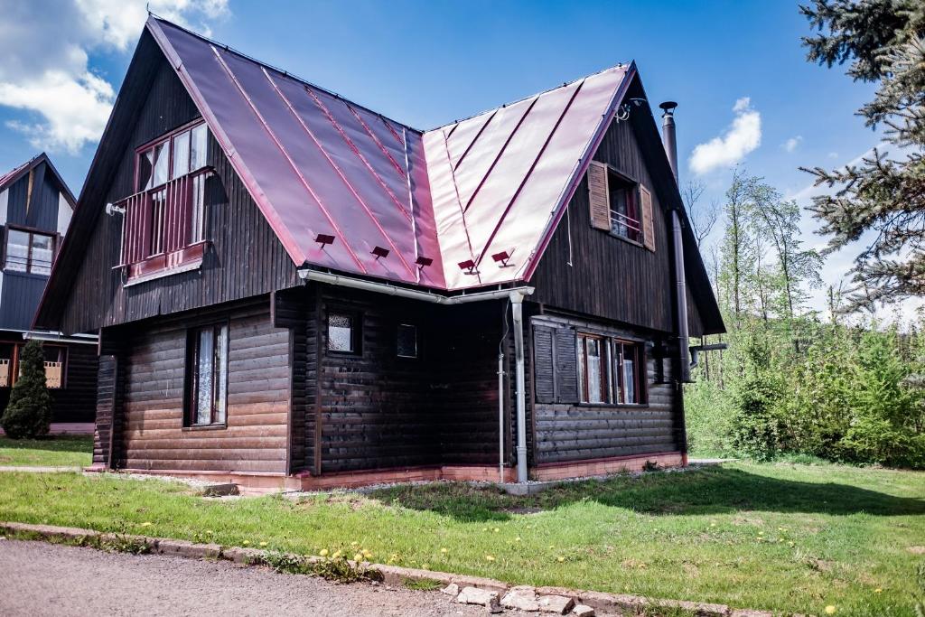 ズラテー・ホリにあるZłota Chatkaの赤い屋根の古木造家屋