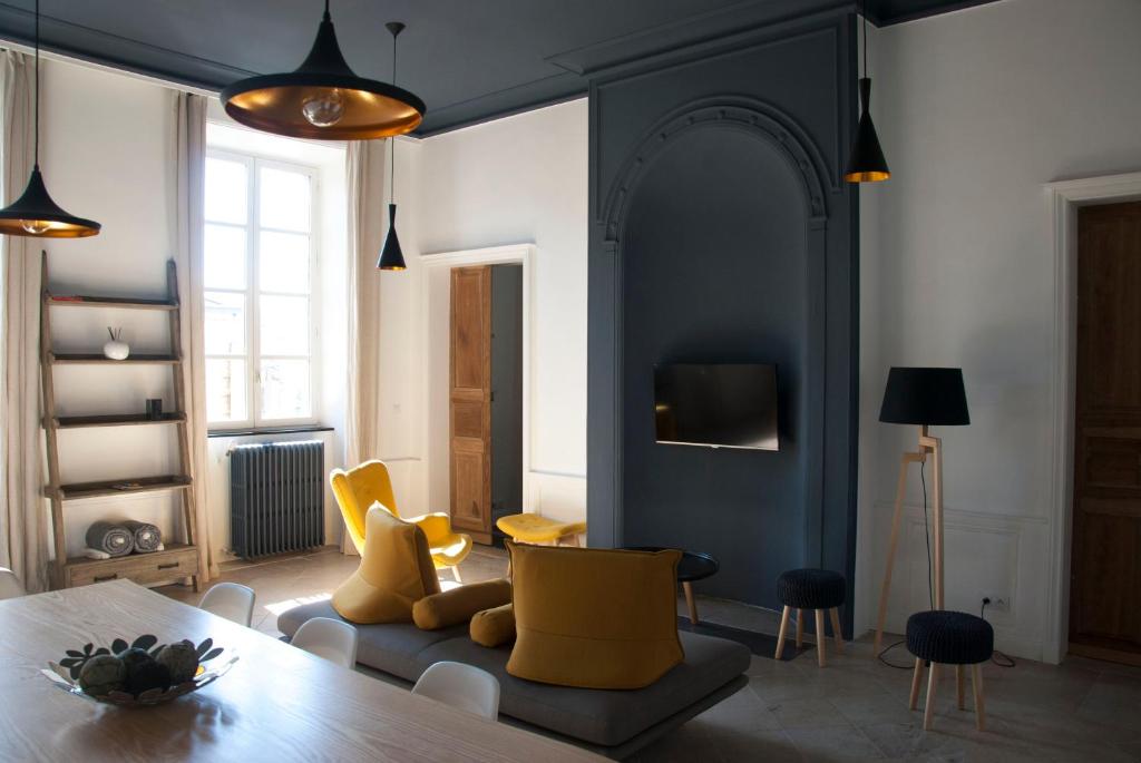 a living room with a table and yellow chairs at Appartement Du Fau De La Roque in Villefranche-de-Rouergue