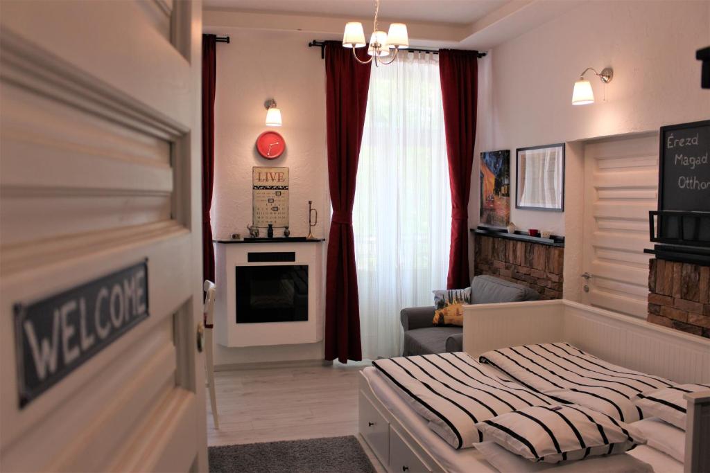 キシュクンフェーレジハーザにあるBelvárosi Apartmanszálló - Kiskunfélegyházaのベッドルーム1室(ベッド1台付)、リビングルームが備わります。