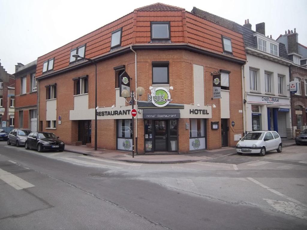 un bâtiment dans une rue avec des voitures garées devant elle dans l'établissement Hotel Restaurant La Cuis'in, à Coudekerque-Branche