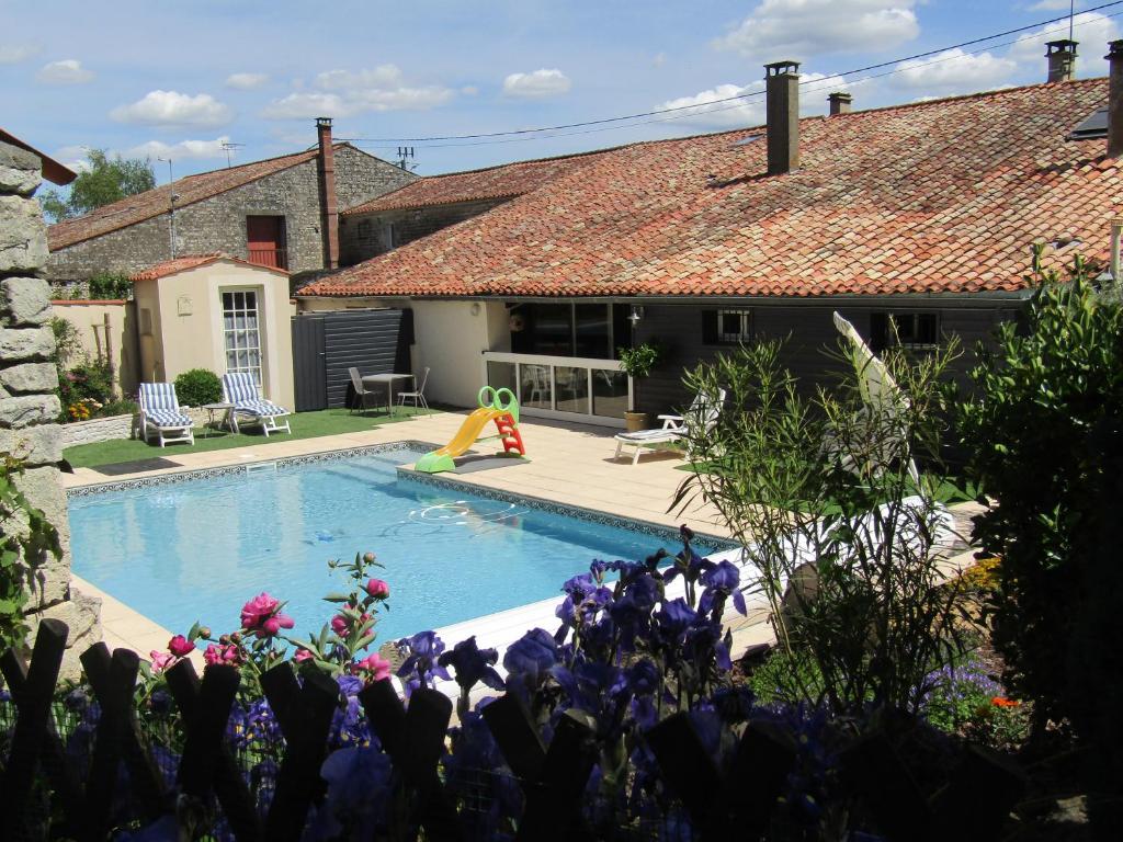une maison avec une piscine dans une cour dans l'établissement La Piaule, à Saint-Pierre-le-Vieux