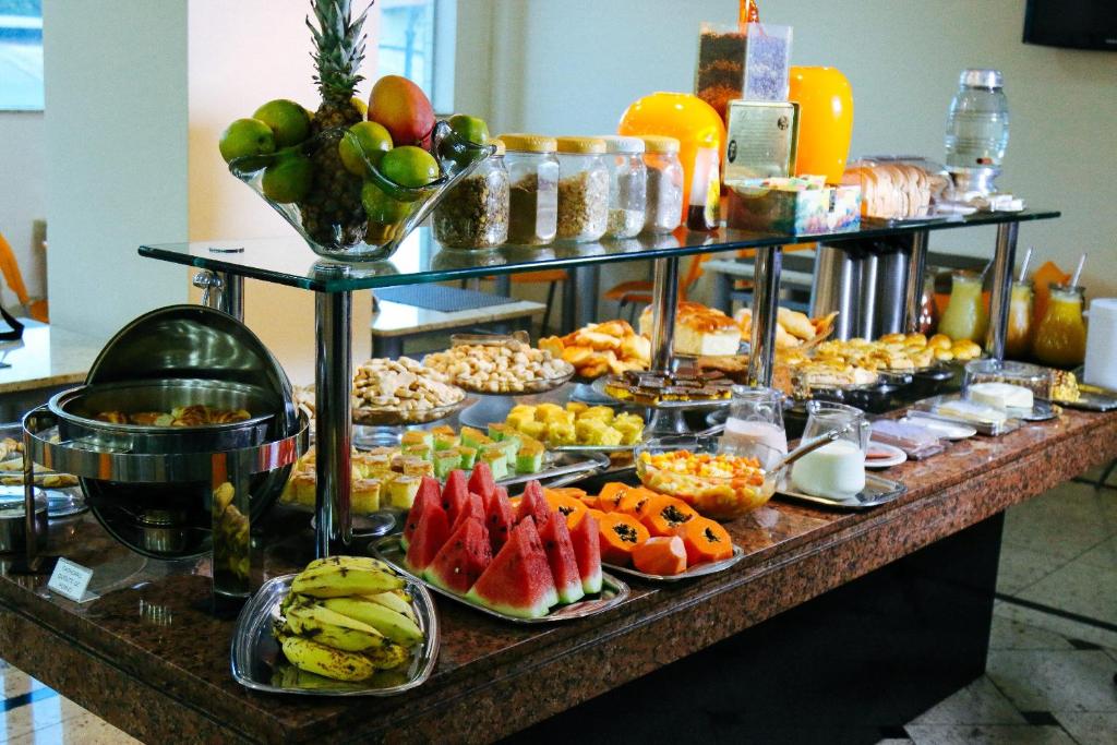 a buffet with fruit and other food on a table at Hotel Pedra Negra Gov. Valadares in Governador Valadares