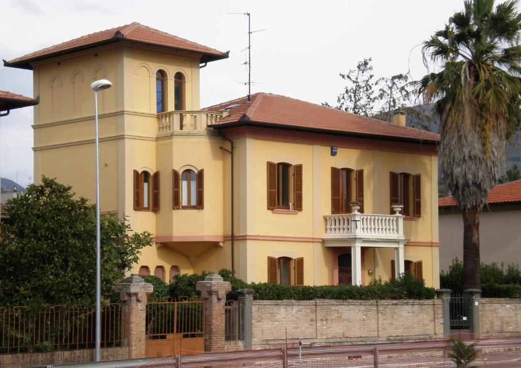 ein großes gelbes Haus mit einem Zaun davor in der Unterkunft Liberty House in Foligno