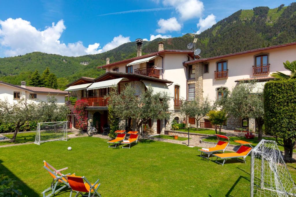 ein Haus mit einem Garten mit Stühlen und einem Tor in der Unterkunft Villa Mariarosa Apartments in Tignale