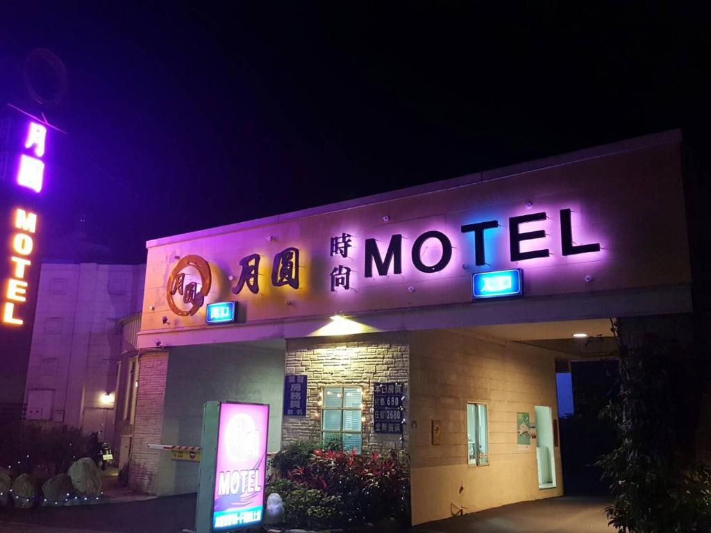 a hotel with a neon sign on top of it at Full Moon Boutique Motel in Hsinchu City