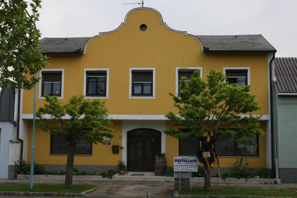 una casa gialla con un tetto rotondo di Appartement Roiss a Podersdorf am See