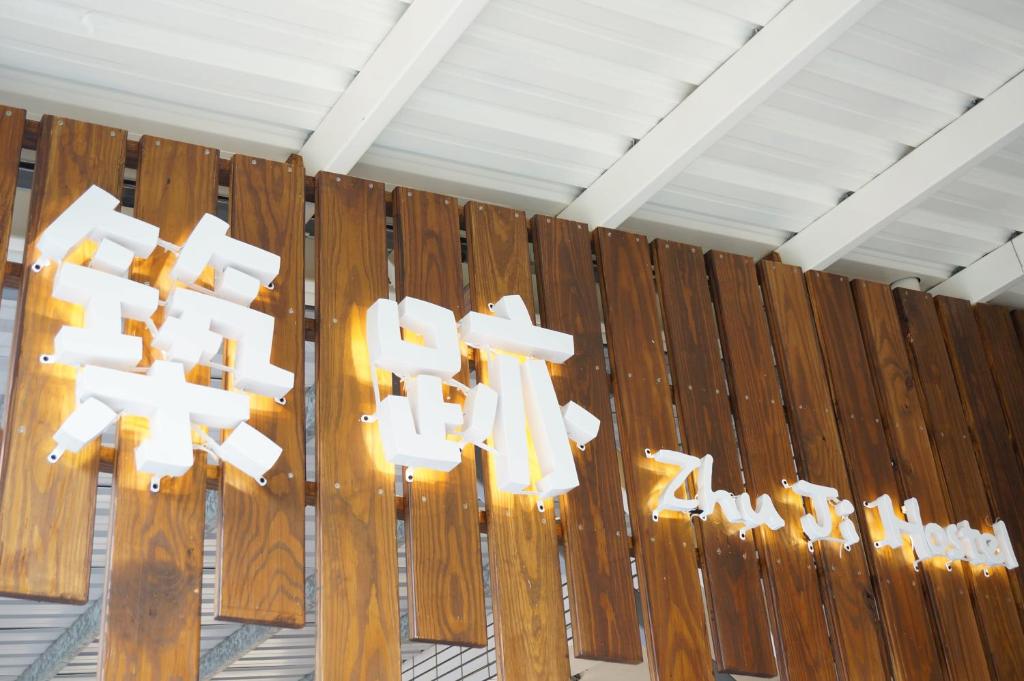 a group of white signs on a wooden fence at Zhuji Hostel in Donggang