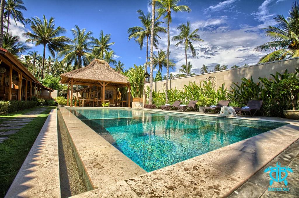 a swimming pool in the backyard of a villa at Benthos Bali Dive Resort in Candidasa