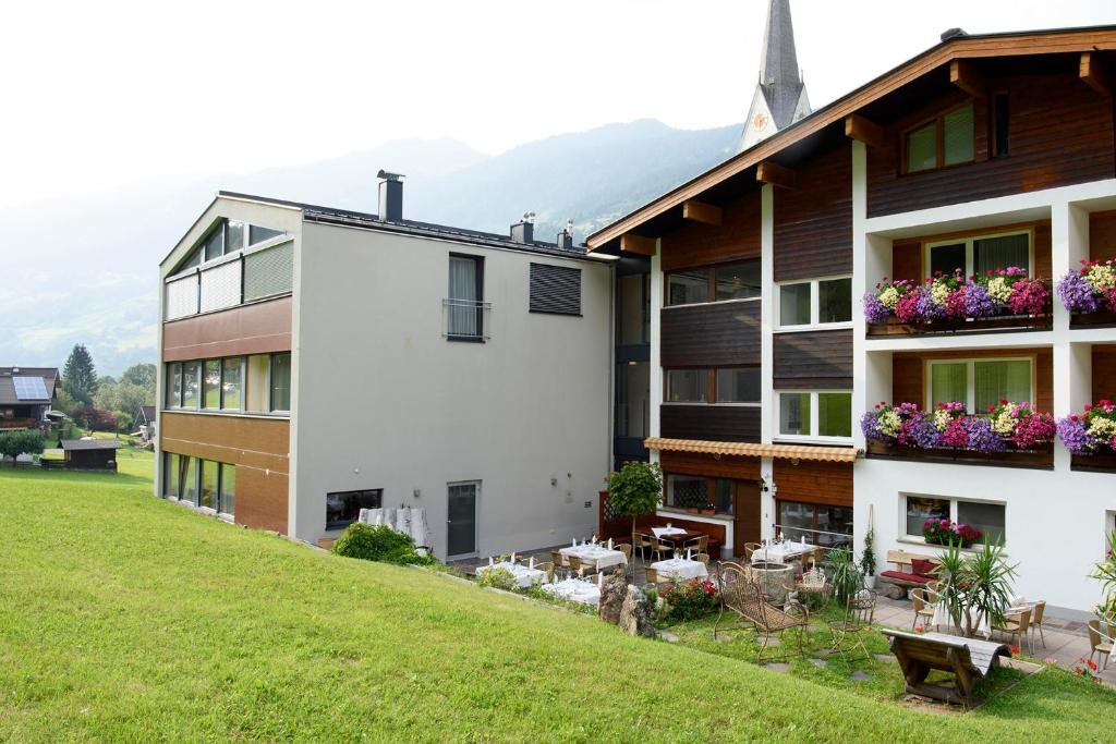 a building with flowers on the balconies of it at Hotel Silbertal in Silbertal