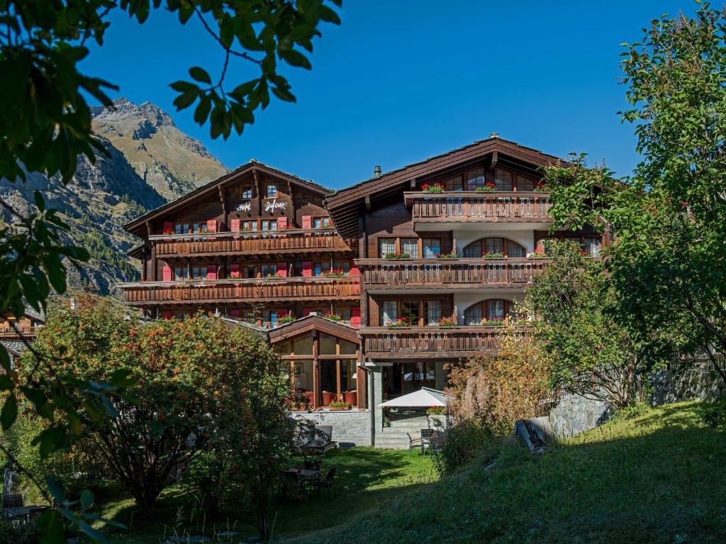 un gran edificio de madera con una montaña en el fondo en Hotel Dufour Chalet - Adults only en Zermatt