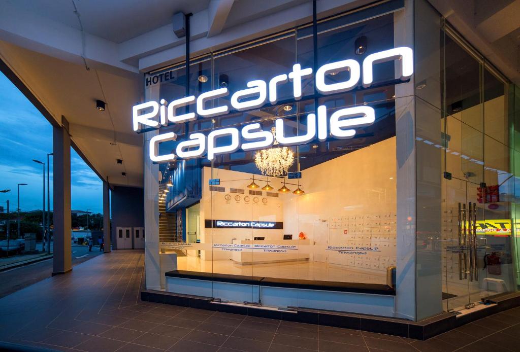 a store window with a reflection of the ricordination capsule at Riccarton Capsule Hotel in Kuala Lumpur