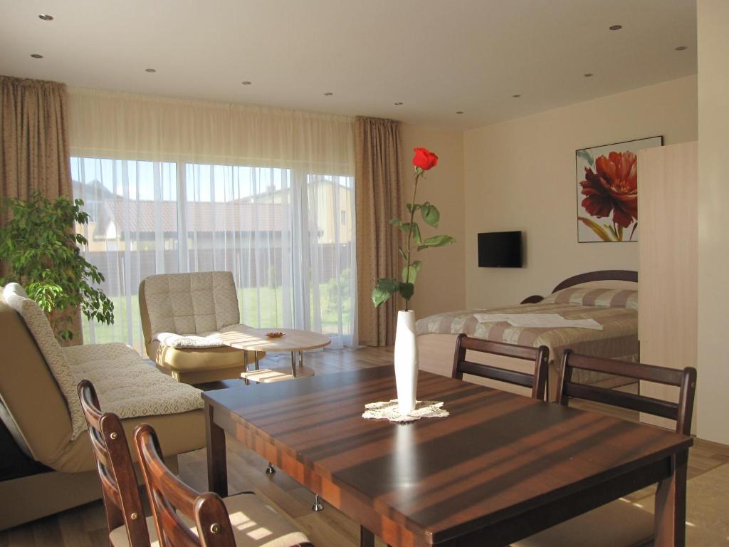 a living room with a table and a bedroom at Vila Laima in Šventoji