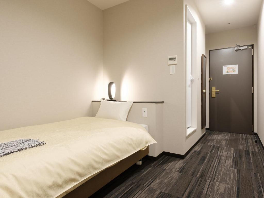 Postel nebo postele na pokoji v ubytování The Premium Hotel In Rinku