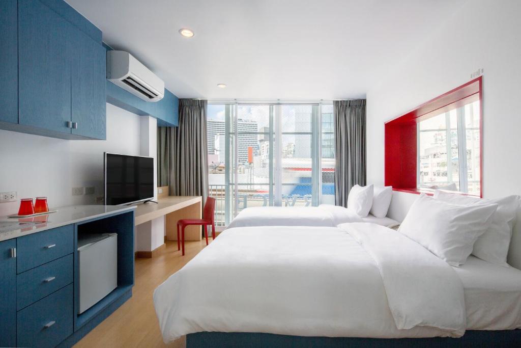 een hotelkamer met 2 bedden en een televisie bij 128 room and massage in Bangkok
