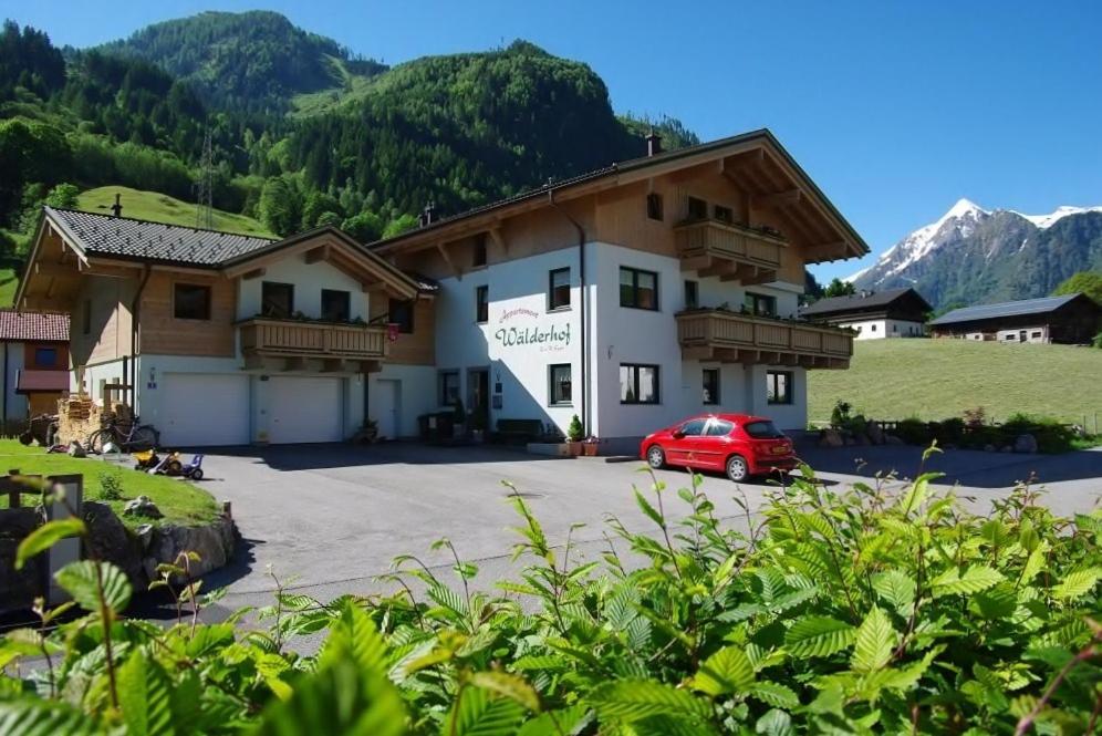 a building with a red car parked in front of it at Appartement Wälderhof in Kaprun