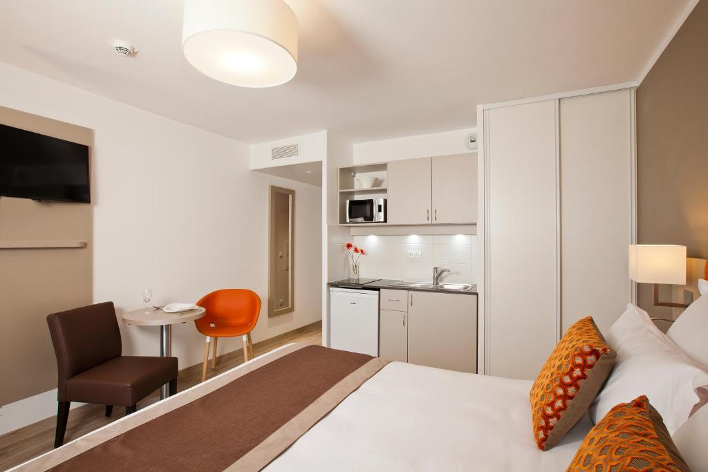 a hotel room with a bed and a kitchen at Residhome Paris Rosa Parks in Paris