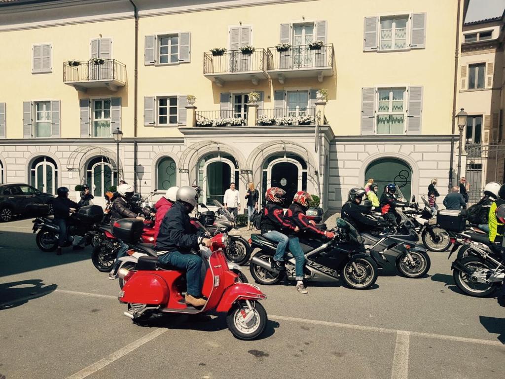 een groep mensen die op een motor door een straat rijden bij Monteverde Apartments in Acqui Terme