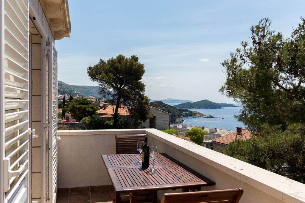 una mesa en un balcón con vistas al agua en Apartment & Room Braica, en Dubrovnik