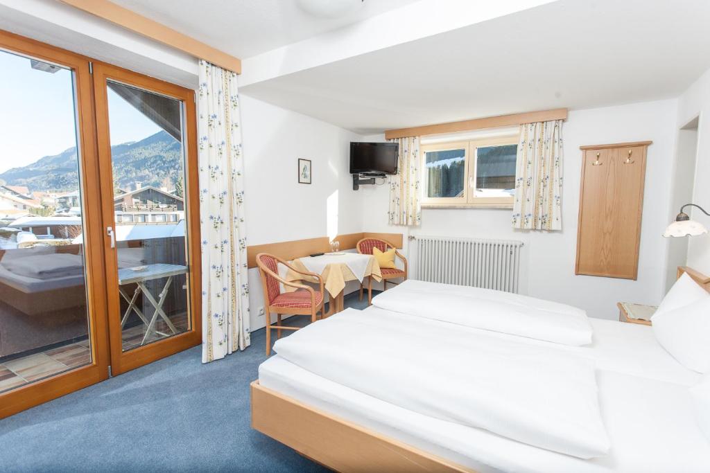 a hotel room with two beds and a balcony at Fideliushaus in Oberstdorf