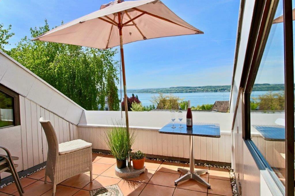 eine Terrasse mit einem Tisch und einem Sonnenschirm in der Unterkunft Ferienwohnung mit Seeblick und Dachterrasse in Überlingen in Überlingen