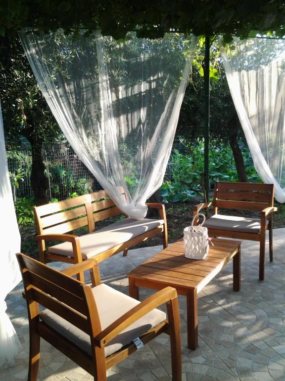 Un grupo de bancos y una mesa con sombrilla. en Fabiene Familyholidays, en Cefalú