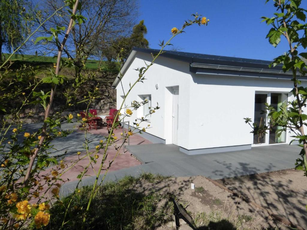 een wit gebouw met een deur in een tuin bij Hainhof Gaestewohnungen in Bad König