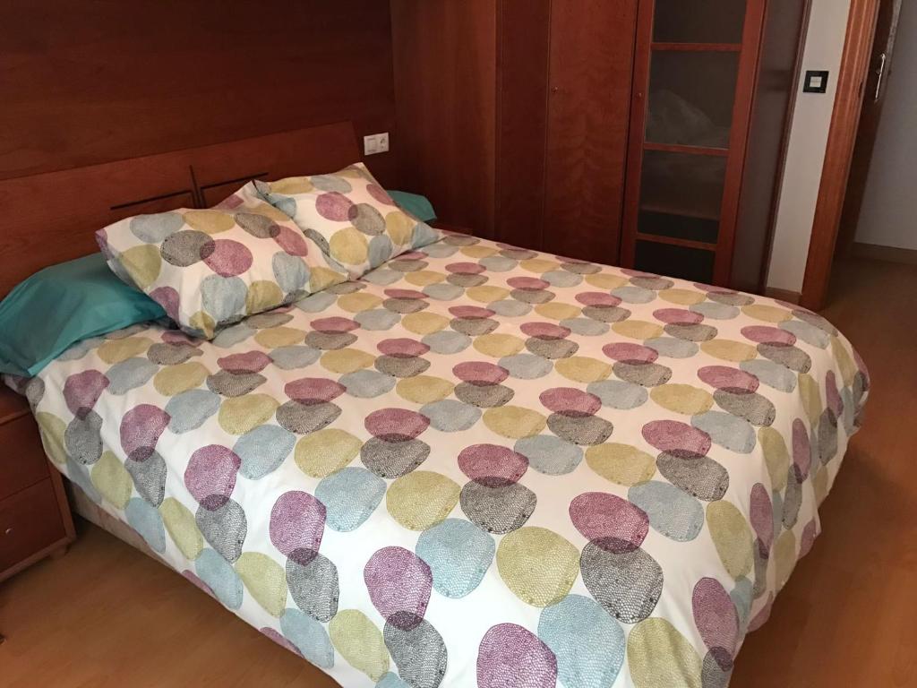 ベニドルムにあるApartamento Turistico Loyolaのベッド(カラフルな掛け布団、枕付)