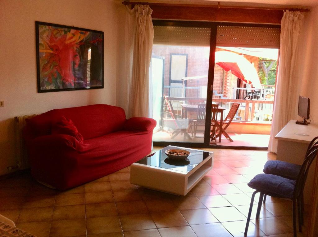 マリーナ・ディ・マッサにあるHoliday Villasのリビングルーム(赤いソファ、テーブル付)