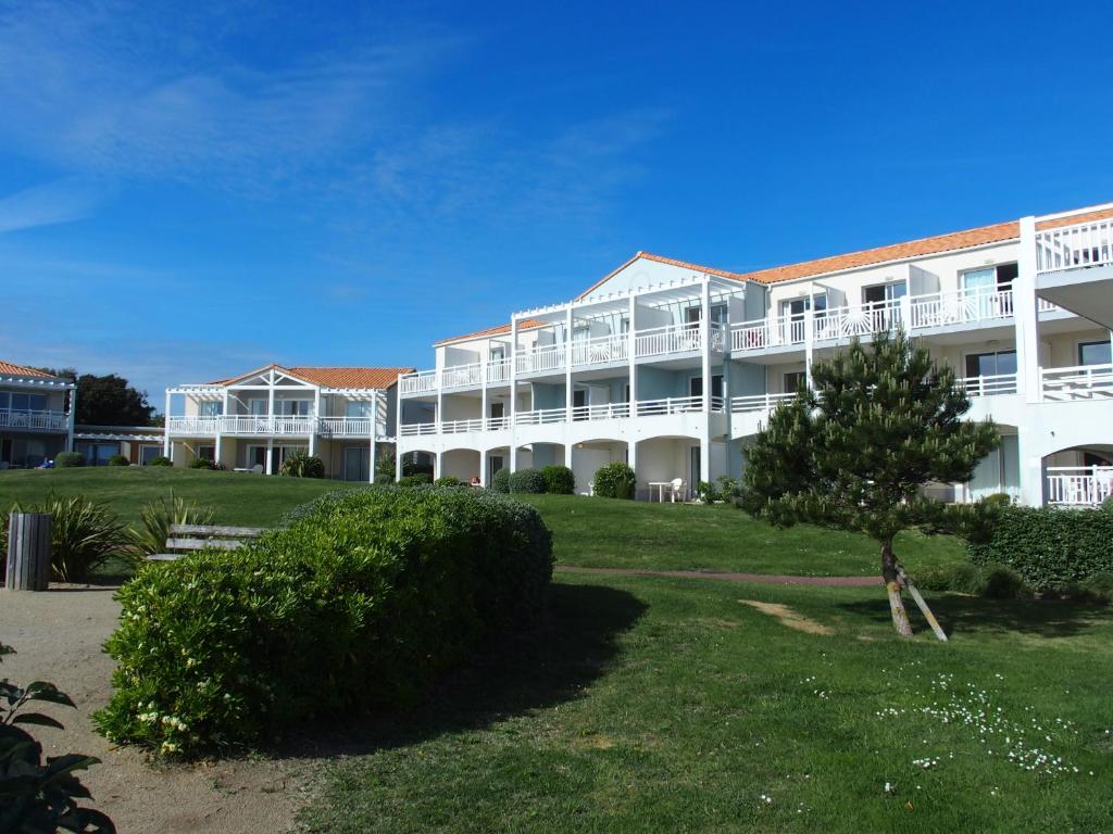 a large white building with a tree in front of it at Appartement - Résidence l'Estran - Sables d'Olonne in Les Sables-d'Olonne