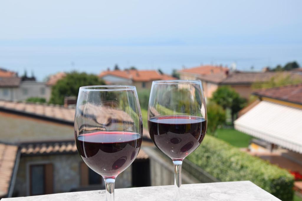 dos vasos de vino tinto sentados en una mesa en Villa Mimosa, en Bardolino