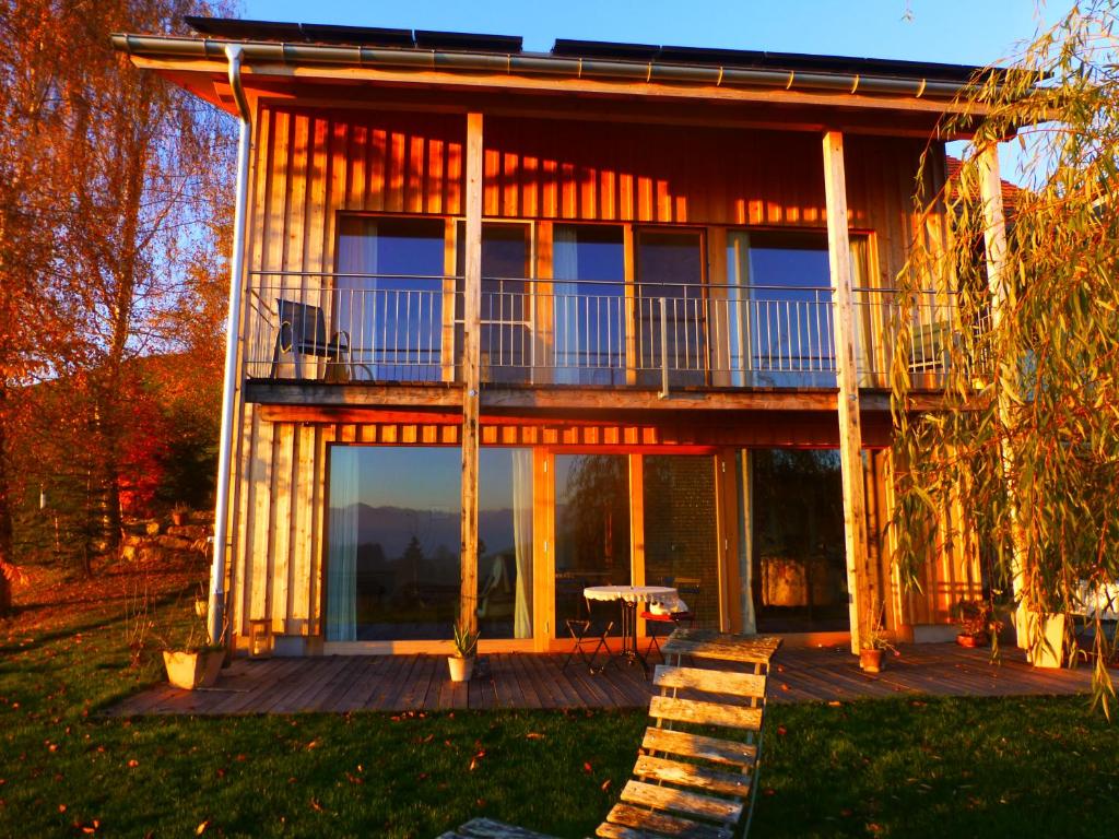 ein Haus mit einem Balkon und einem Tisch auf einer Terrasse in der Unterkunft B&B Winzenberg in Lütisburg