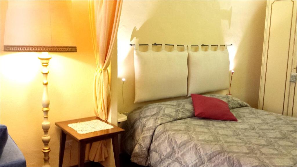 シエナにあるcasa Beccheriaのベッドルーム1室(ベッド1台、テーブル、ランプ2つ付)