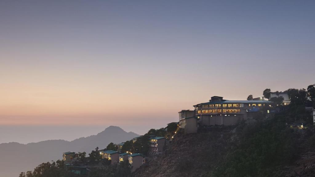 un edificio en la cima de una colina al atardecer en Sterling Mussoorie, en Mussoorie