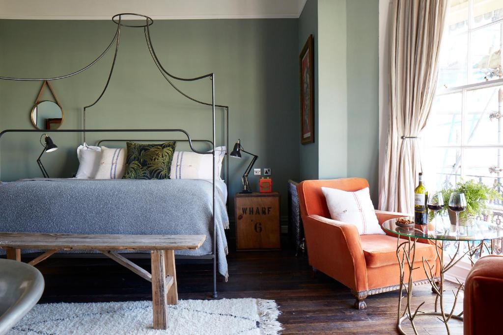 a bedroom with a bed and an orange chair at Artist Residence Brighton in Brighton & Hove