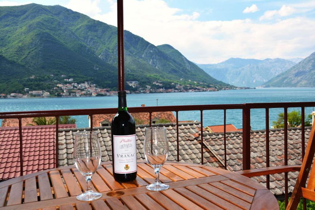 a bottle of wine sitting on a table with two glasses at Apartment Biser in Kotor