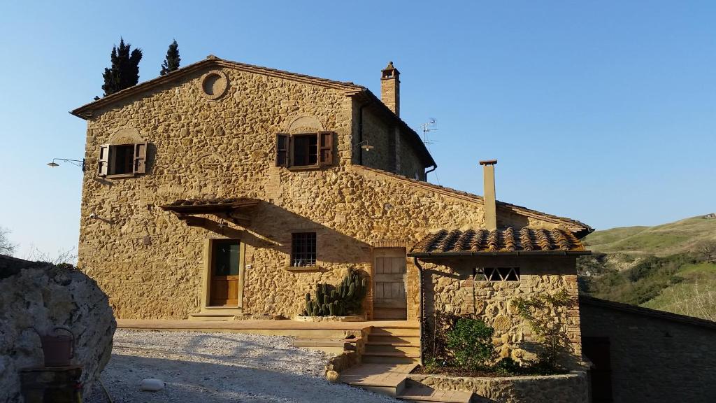 a large stone house with a stone wall at Agriturismo La Quiete in Volterra